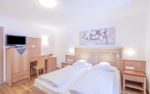 Schlafzimmer mit Doppelbett und Fernseher - Suite Superior